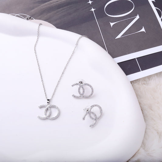 طقم شانيل – قطعتين بزركون ناعم فضي ✨💎